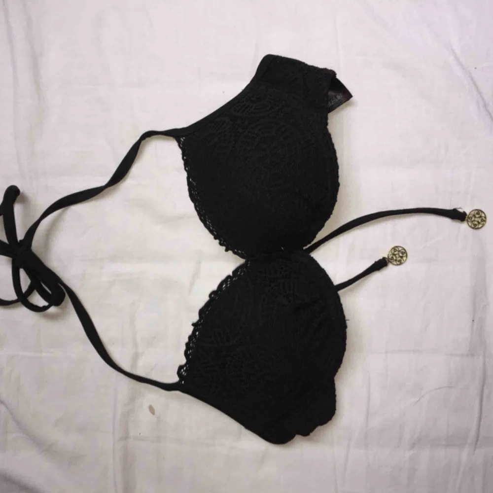 Fin svart bikini i spets från H&m. Med två ”snören” med små detaljer längst ner(se 3:e bilden). Adligt använd pågrund av att den är förstår. (Lite push up) köparen står för frakten🙂. Övrigt.