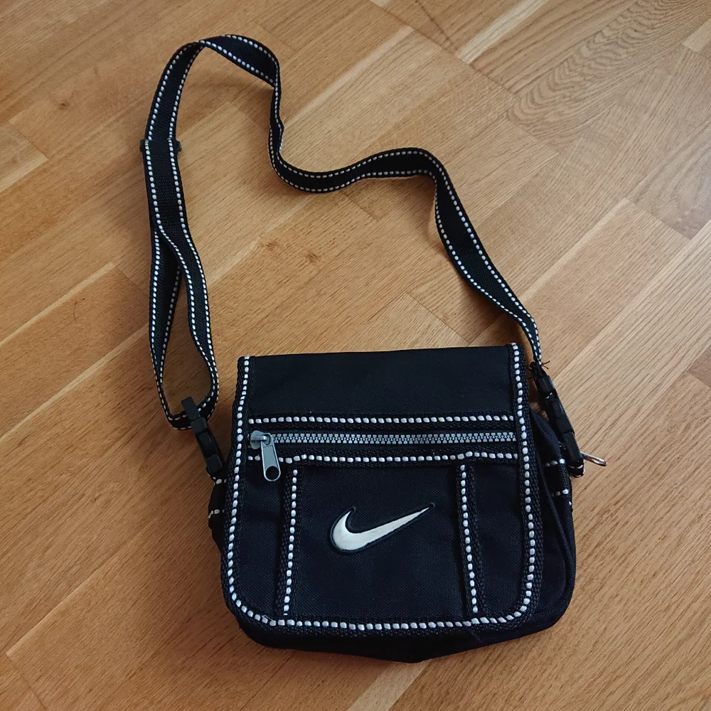 Mindre svart väska från Nike med justerbar axelrem, i fint skick! . Väskor.