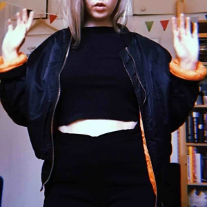  - vintage svart och orange bomberjacka. Hittar ingen storleksmarkör men den sitter såhär på mig som brukar ha typ S.