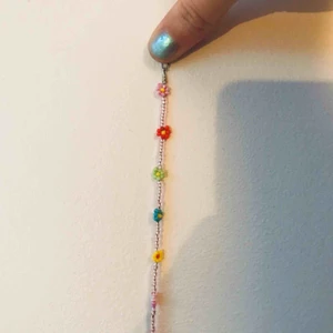  - Pärlarmband med blommor. 16 cm långt men kan anpassas efter önskat mått. 