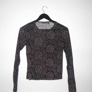  - Transparent, mönstrad, stretch tröja i gott skick. Svart bas med beiget och brunt mönster.  Köparen står för frakten 🌺