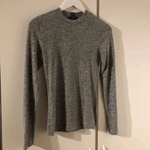  - En grå tunn stickad långarmad. Ny.