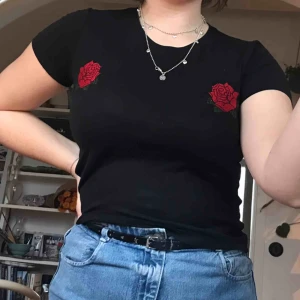  - Tajt, svart topp med rosor som detaljer. Sällan använd och köpt på Bikbok i storlek XS.