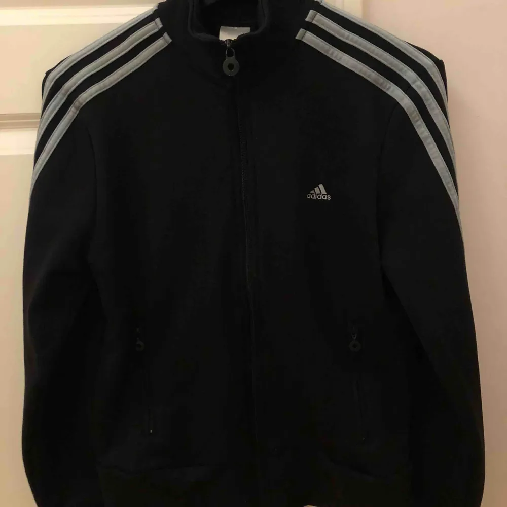 Jättecool svart Adidas tröja med grå detaljer!! Det står på lappen att den är i storlek 42, men den är extremt liten i storleken. Köpare står för frakt <33.. Hoodies.