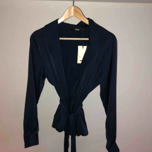  - Blus som knyts omlott från Bik Bok, ny med lapp kvar.  Nypris 299kr