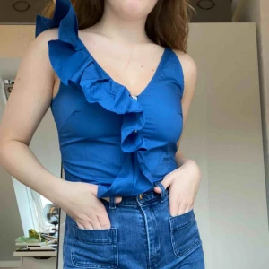  - Ball blå urringad blus från HM men volang längs ena sidan. Omsluts med den dragkedja framtill. Lite croppad. Använd ett fåtal gånger. Frakt tillkommer. Skriv för mer info.