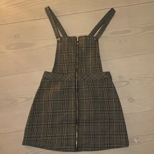 Klänning från Hm - Hängselklänning från HM, köpt i Thailand däröfr är prislappen konstig, strl S men tycker den är lite större för att vara en ”petit” ganska kort däremot. Den här silvriga detaljer, man kan justera banden eller ta loss dom där fram  då det är knappar