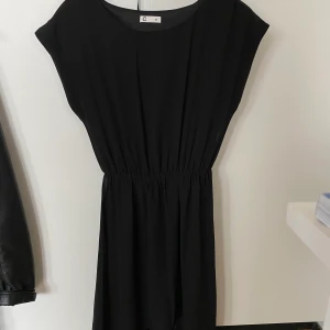 Svart klänning 34/36 - Svart klänning som är längre baktill, från Cubus strl 34 men jag skulle säga att den passar 36 också. Fint skick! Kan fraktas om köparen betalar frakten. Hund finns i hemmet!