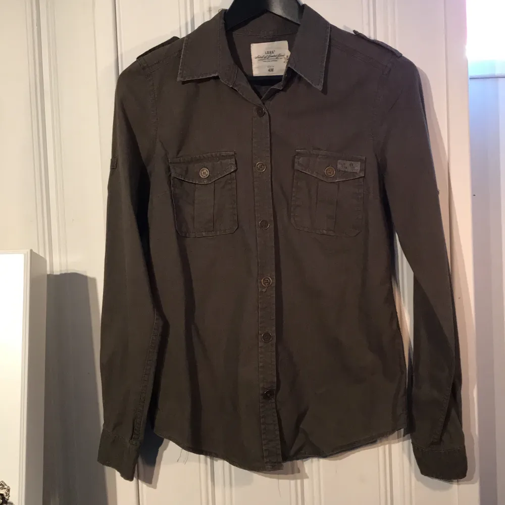 Snygg skjorta från HM i khakigrön med knappar i brons. 50kr +frakt . Skjortor.