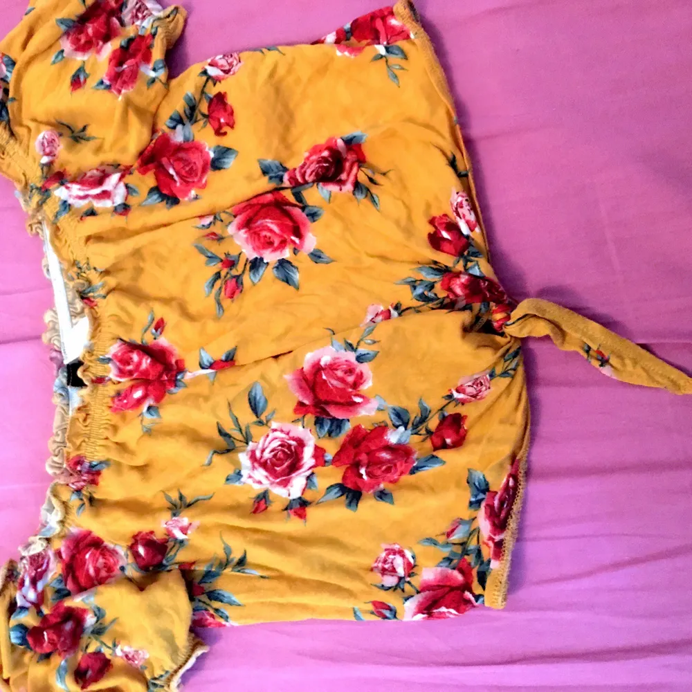 Bright yellow crop top with pretty red flowers . Toppar.