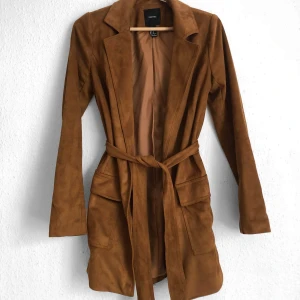 Suede Kappa • Forever 21  - Underbart fin kappa/jacka i brun suede. Funkar lika bra utan snöret i midjan. Passar dig bäst med storlek S, men funkar även för XS och mindre M. Kappan är oanvänd och har två stora fickor på vardera sida. Materialet är så fint!