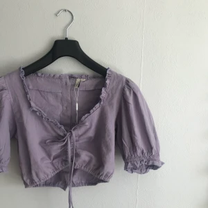 Topp - Söt topp från Nelly. Bara använd på bild ( man kan justera längden vid knytningen )