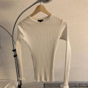 Vit ribbad topp 36 - Vit ribbad topp från Topshop. Jag har sytt upp ärmarna (inte så jättefint sytt). Ser konstigt ut på bild men är bättre när tröjan är på. Går enkelt att sprätta upp om man vill det. 