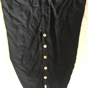 Kjol med knappar  - En kjol som kan knäppas upp hela vägen. Är lite öppen framme längst ner och är använd en gång och säljer pågrund av att den är för stor i midjan. Är lite skrynkig efter ja tvätta den. Måste strykas. 