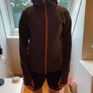 Houdini - Jag säljer en grå Houdini med orange kedja som tyvärr är för stor för mig. Den är i väldigt bra skick och har bara används några få gånger. Annars är den väldigt skön och passar till alla aktiviteter.