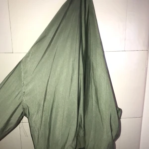  - Stor militärgrön bomberjacka, den går så långt som möjligtvis lite över rumpan. Den är inte jättelång.