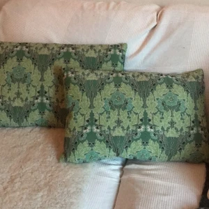  - Två fina kuddar från Åhléns, blommigt grönt mönster som ser ut som brodyr. Säljer 1 för 50kr och båda för 70kr