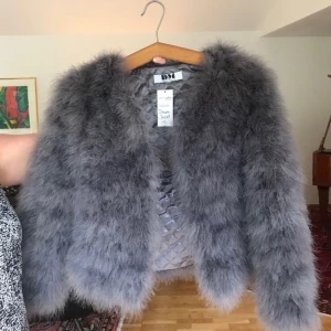  - Grå fluffjacka, aldrig använd, nypris 1399. Köparen står för frakten