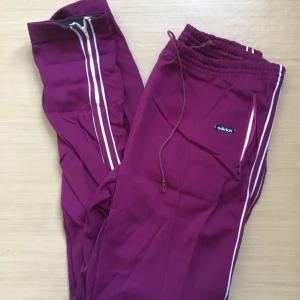  - Adidasbyxor i lila. Vintage! Ganska stora men man kan dra åt dom. 