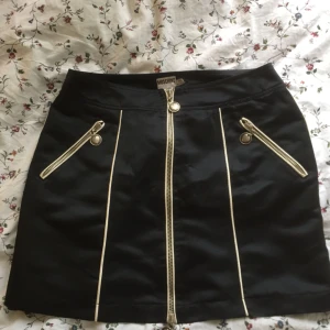  - Kjol från Moschino med snygga detaljer i silkigt material, storlek S. Kan mötas upp i Lund, köpare betalar frakt. 