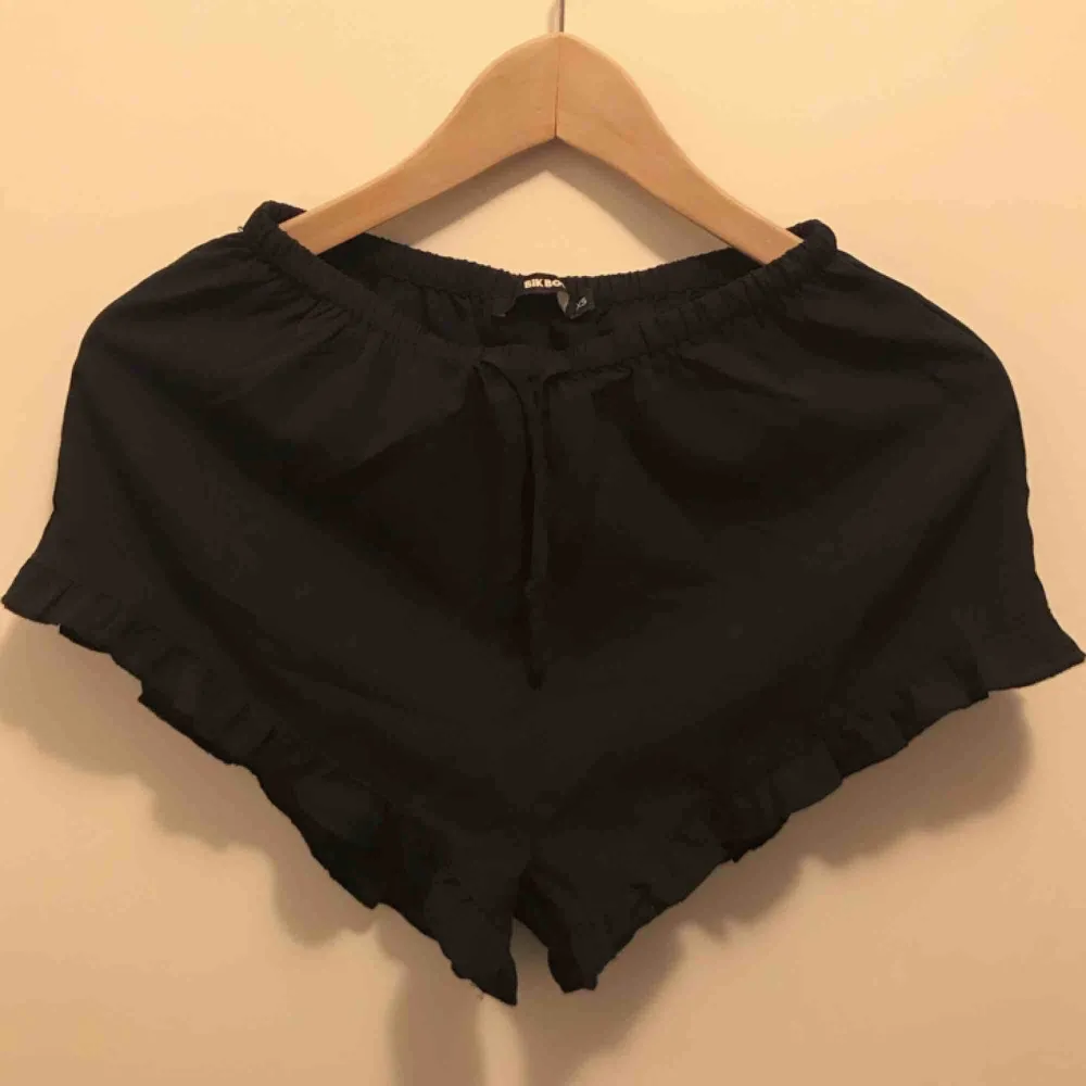 Svarta tunna shorts med volangkant från BIKBOK. Strl XS. Pris: 20 kr. Shorts.