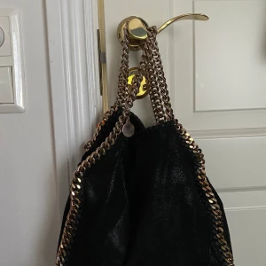 Stella McCartney falabella mini - Säljer min stella falabella mini väska. Köpt för ca 2 år sedan på farfetch. Har tyvärr inte kvitto kvar men den är givetvis äkta. Ursprungspris på denna väska är på Stellas hemsida 8650 kr men just denna färg går ej att köpa längre. Den är svart med guldig kedja. 