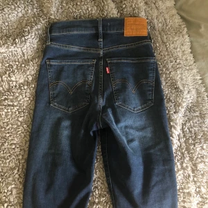 Levis jeans - MILE HIGH SUPER SKINNY.                              Snygga, högmidjade, marinblåa Levi’ jeans. Endast provade i provrum samt på bild, byxorna är i nyskick✨✨ Stolek: 26, (men väldigt stretchiga).             Märke: LEVI’S ✨✨