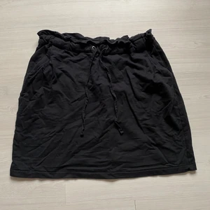 Svart mjukiskjol - Svart mjukiskjol med snören i midjan och fickor där fram (bakfickorna är fake) Köpt på Gekås Ullared men ändå bra kvalle;) Frakt: 45kr