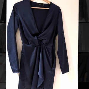 Marinblå siden klänning, strl 36 - Fin sidenklänning från Nelly, går till ovanför knäna, har både slits och fin överlappning vid brösten. 