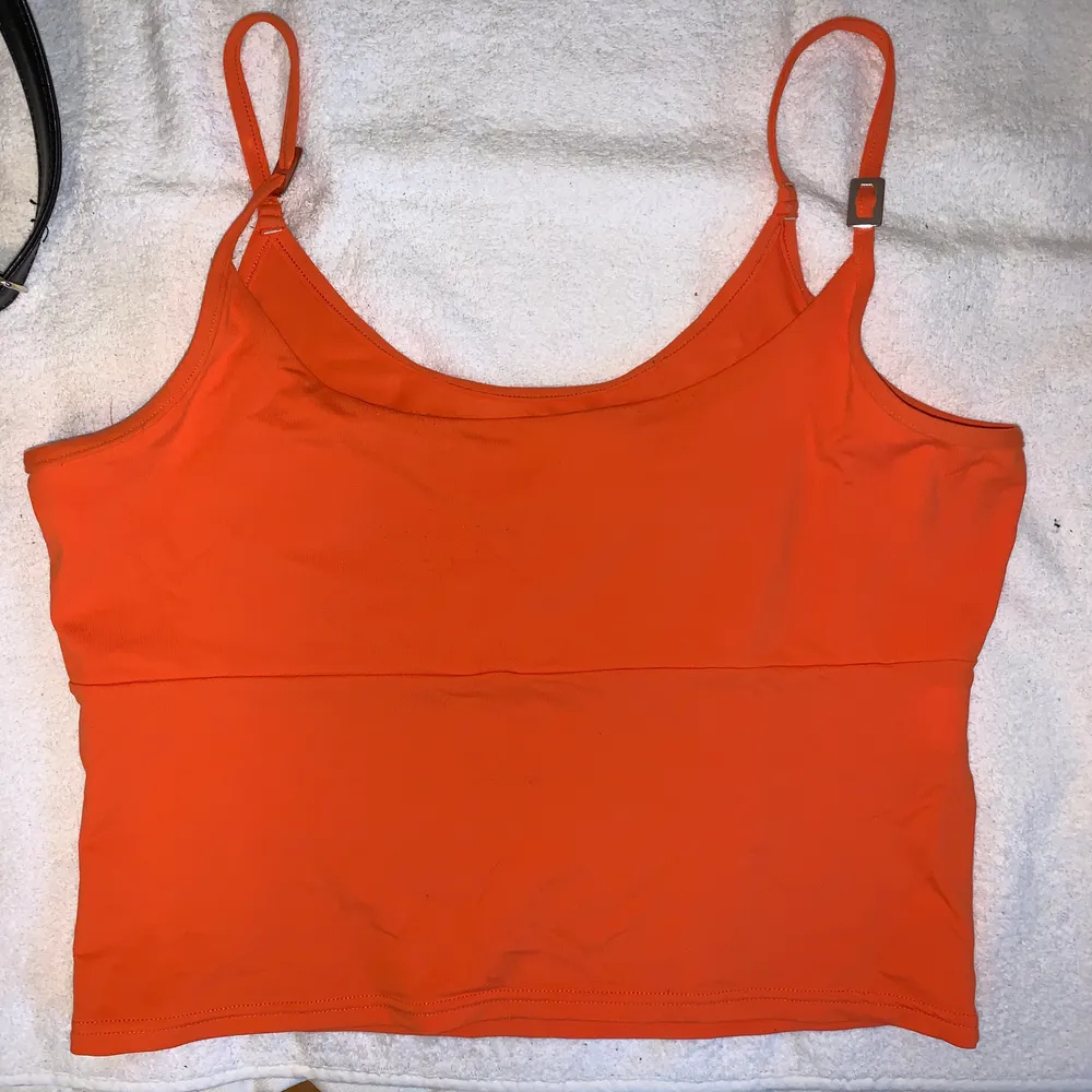 Najs orange linne i typ glansigt stretch material😇står ingen storlek men skulle gissa typ S/XS😇köparen står för frakt 60kr😇. Toppar.