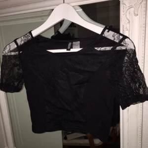  - Svart crop top med spets detaljer från H&M i storlek XS, använd en gång.