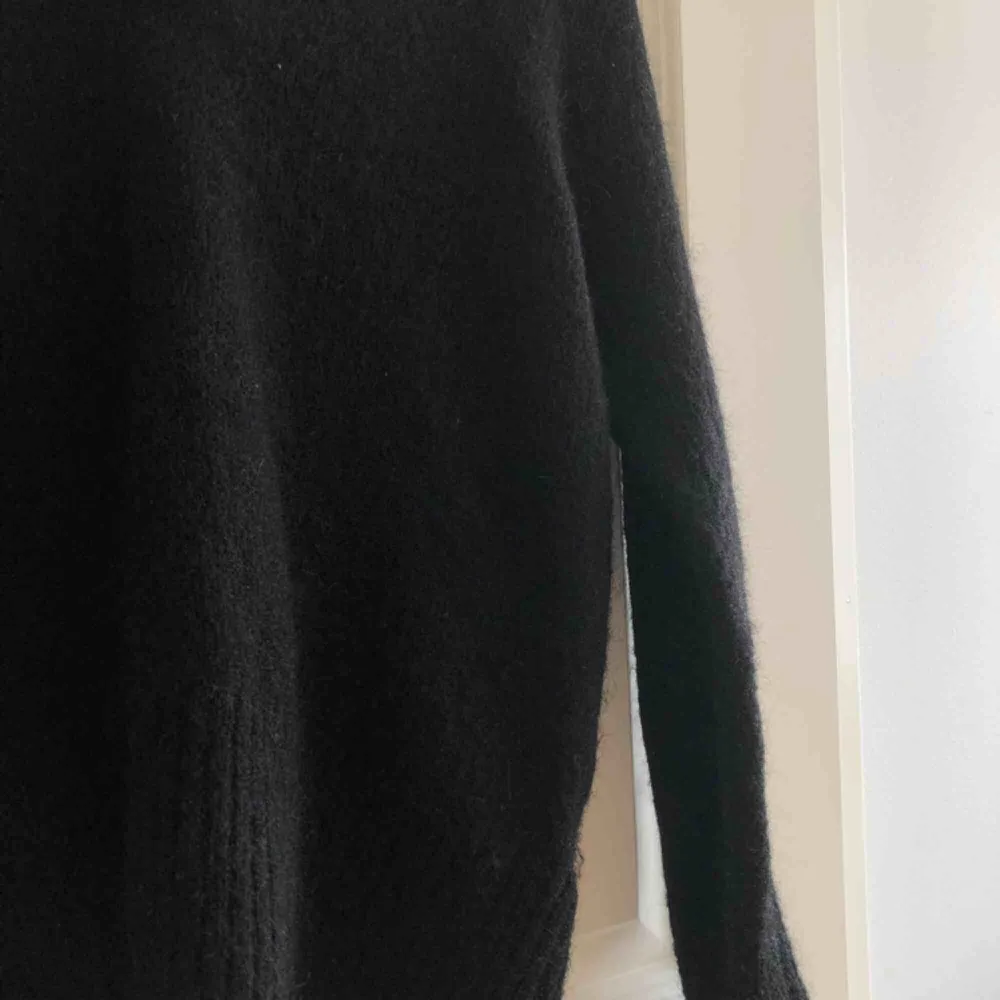 Svart stickad tröja i snygg design. 25% mohair, 25% ull. Möts i Stockholm eller köpare står för frakt.. Stickat.
