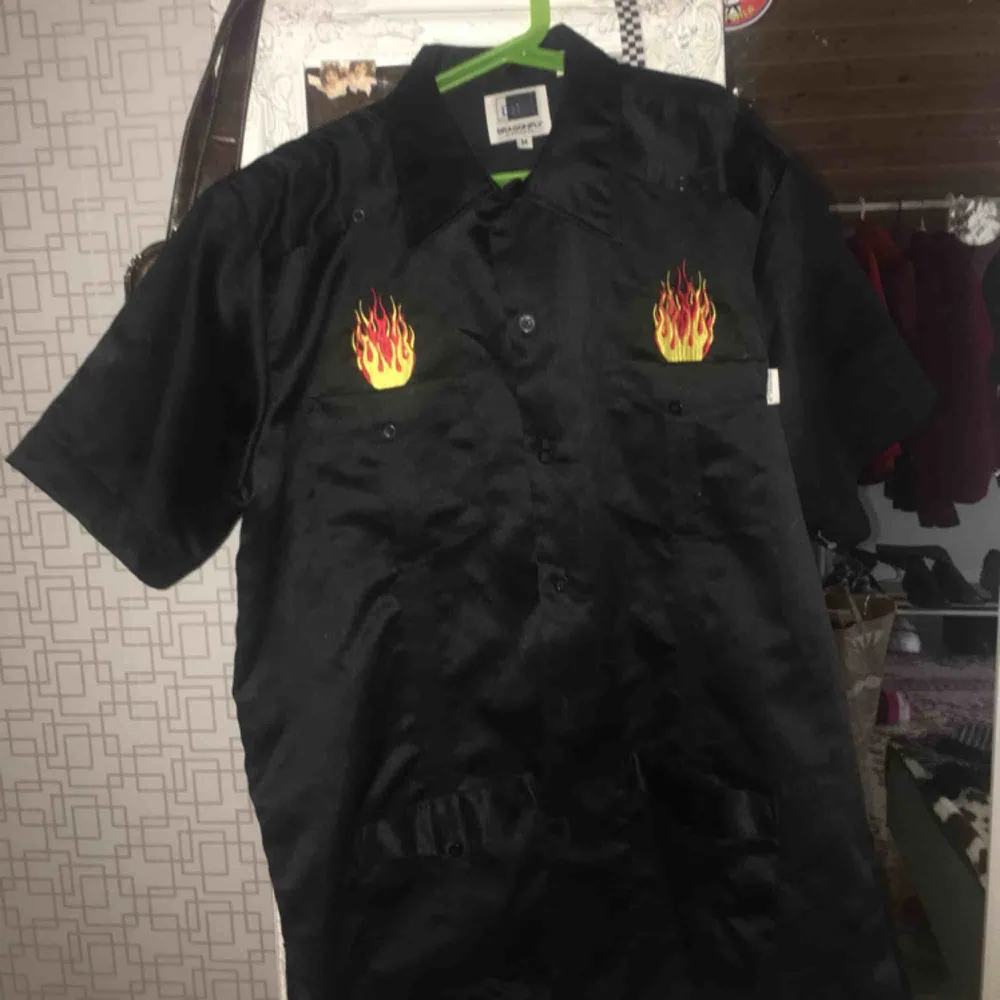 Supercool skjorta med eldflammor vid fickorna! Väldigt stor och oversized, med en cool ribbad detalj. Bra skick, frakt tillkommer.. Skjortor.