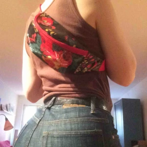  - En jette fin svart magväska med blommotiv i plast. Inte lik många andra, unik!