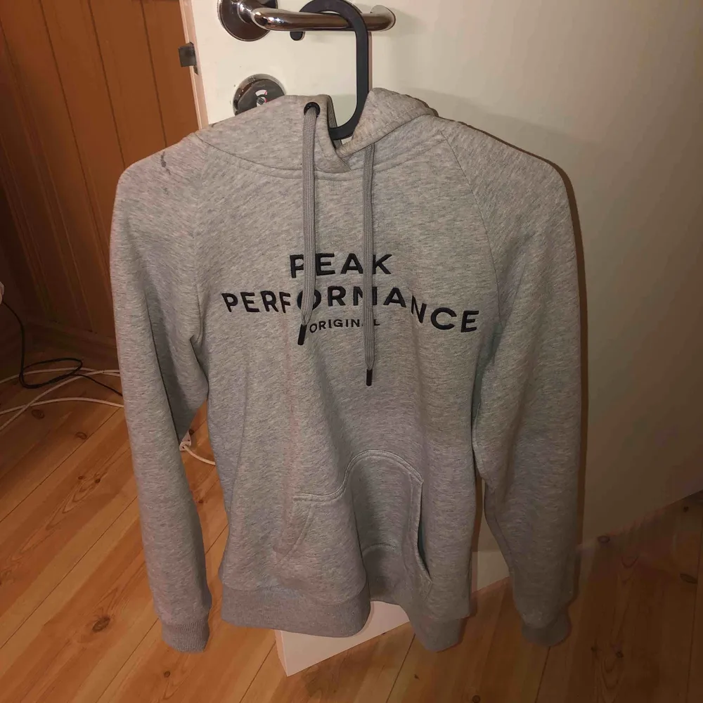 En grå peak performance hoodie som är snygg, skön och sitter bra. Priset kan diskuteras . Hoodies.