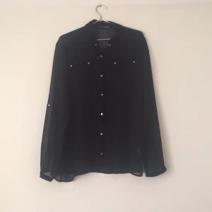  - Transparent blus med silverknappar. Väldigt tunnt tyg.