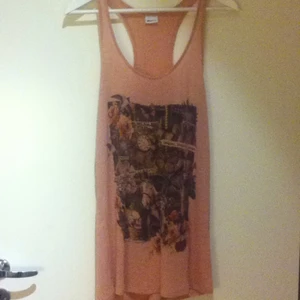  - Löst sittande, rosa linne med tryck. 100 % viskos och kan tvättas i 30 grader. Använd ett fåtal gånger som oversize. Köpt på Gina Tricot.