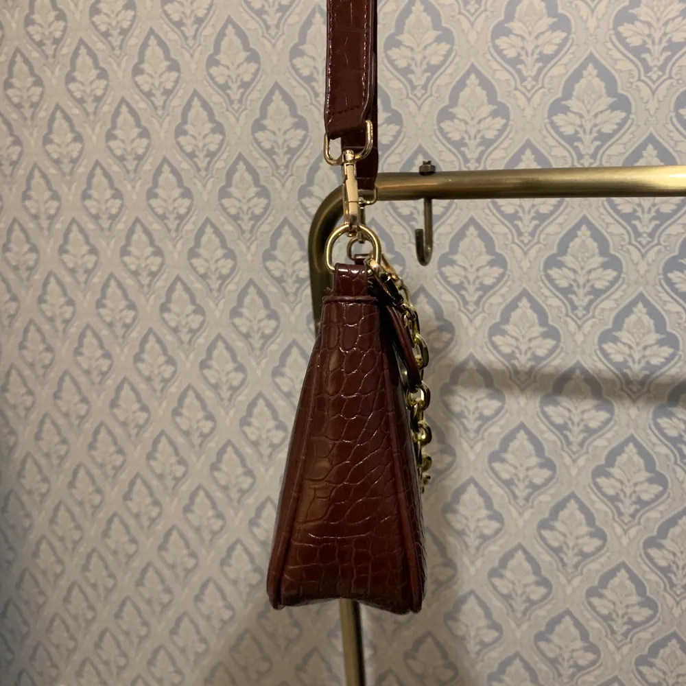 Oanvänd baguette bag från shein(där av de billiga priset) jätte fin brunfärg, guldkedjan går även att ta av. Den är ca 26x14,5. Den har ett litet fack med dragkedja inuti, kan skicka bild på insidan. . Väskor.