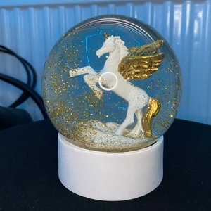 Glasglob  - En glasglob jag haft i mitt rum i närmare ett halv år, inga repor eller skador precis som nyköpt. Det är en stor glasglob med en unicorn staty med guld färgad glitterflingor i glasgloben.