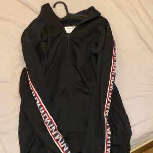 Svart Kofta med detaljer - En snygg tröja från vailent med mönster detalj på armarna.