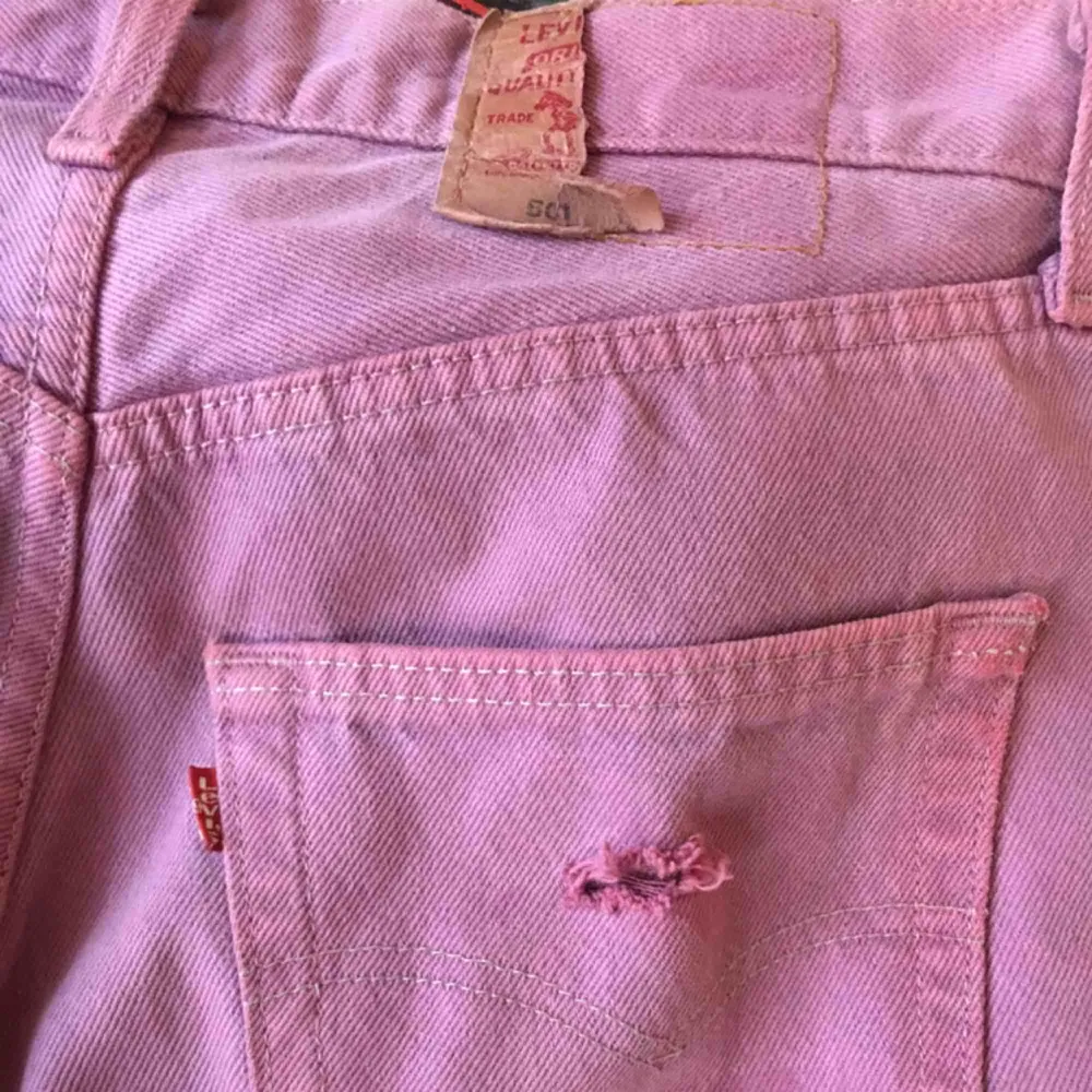 Lila Levi’s 501. Ingen storlek men passar mig som är en s/m. Jag är 160cm. Byxorna är snyggt slitna. Liten vit fläck på högra låret men kan nog gå bort i tvätten. Märkes-lappen på rumpan är även trasig men annars är byxorna i gott skick.. Jeans & Byxor.