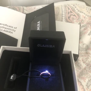 Äkta guld ring med vit safir - Beskrivning på bilden. Säljer då den inte passar tyvärr. Ny pris 5000kr . Certifikat finns o kvitto. Stl 16. Vid snabbaffär kan priset diskuteras