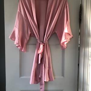 Morgonrock från Victorias secret, silke, rosa, kort med volanger i ärmar och på botten, knappt använd, supersnygg. Frakt ingår ej i pris.