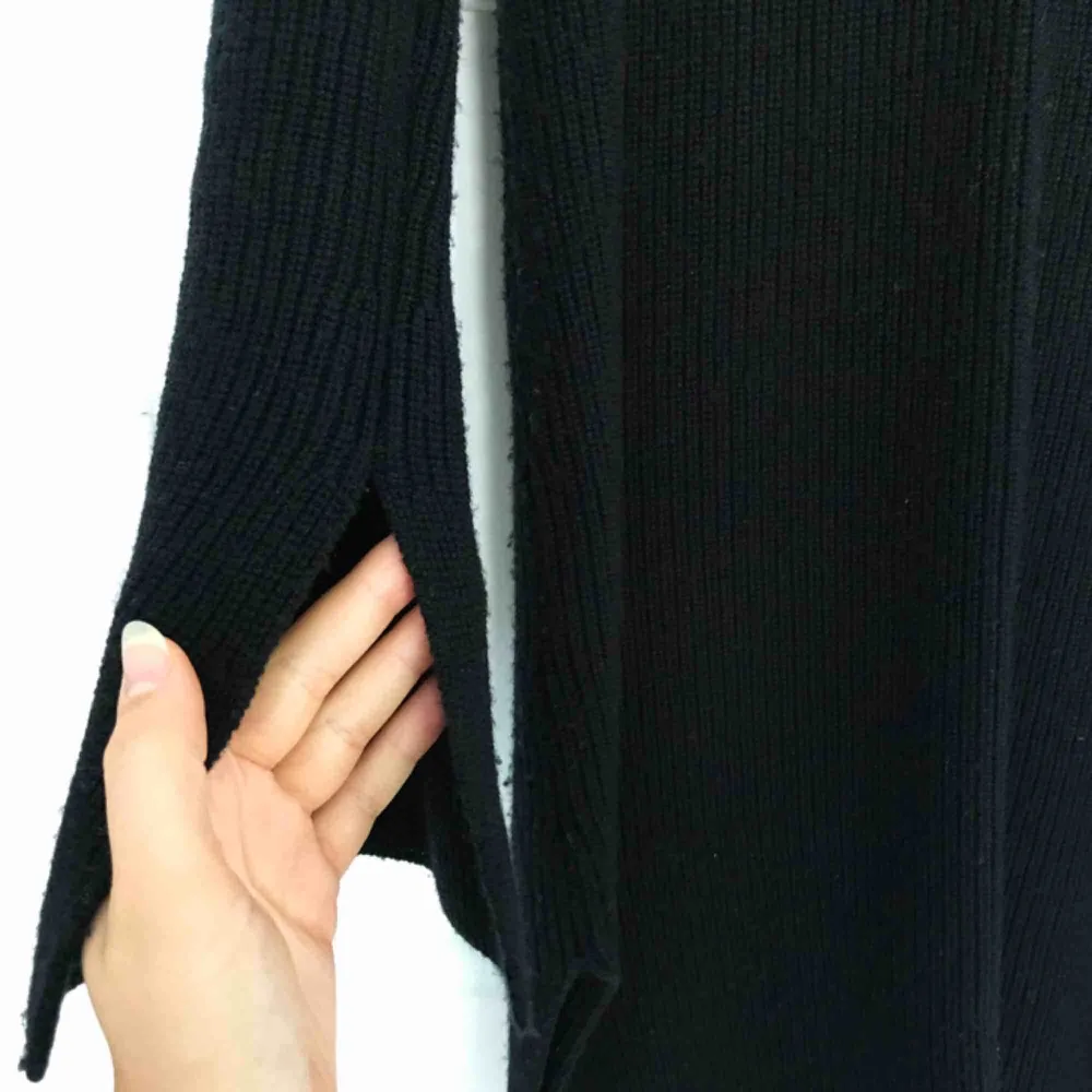 Lång stickad tröja från Filippa K med slits i både ärmslut och sidor. Något nopprig och därav det låga priset. Stickat.
