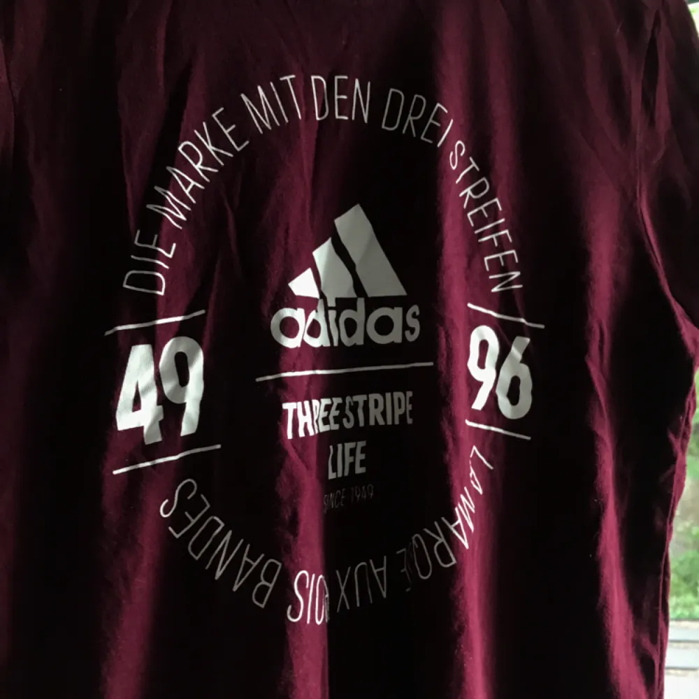 Sparsamt använd Vinröd Adidas T-shirt med tryck på framsidan nypris 249 kr säljes pågrund av används inte. Köparen står för frakt . T-shirts.