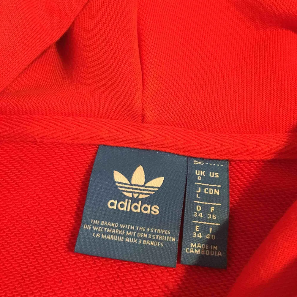 Röd adidas hoodie i jättebra skick!  Köpt i storlek S men skulle säga att den är lite oversized. Frakt är inräknat i priset. Hoodies.