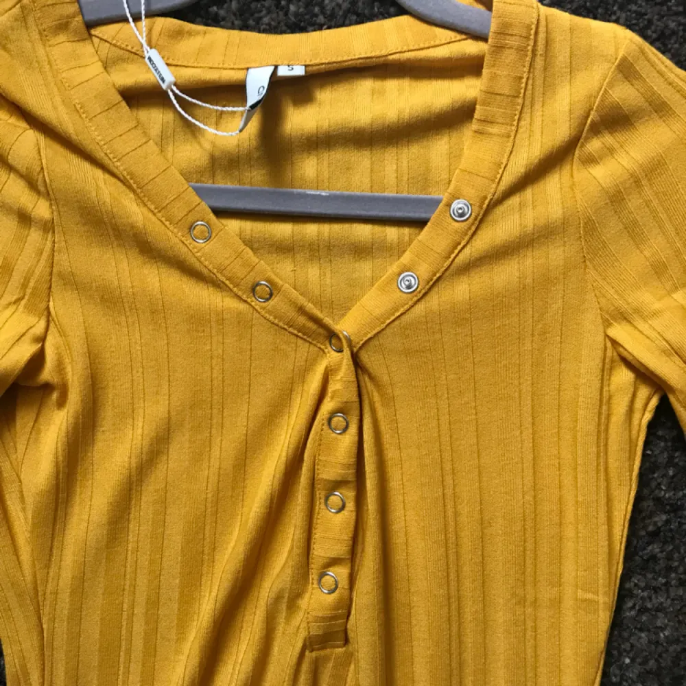 En helt ny gul tröja från Nelly. Är i storlek S, knappar som går att stänga och öppna. . Tröjor & Koftor.