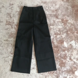  - Svarta byxor, tunga i materialet. Ska sitta högt i midjan 