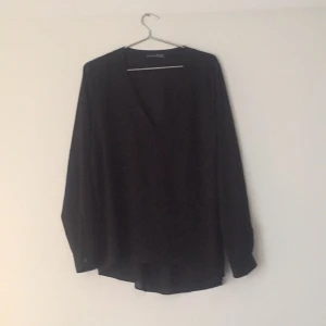  - Oversized transparent blus. Låg v-ringning. 