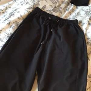  - Fina svarta byxor, aldrig använda! Finns resårband nertill på baksidan, fint och smart då det inte syns när de är på men man får ändå in anklarna :)